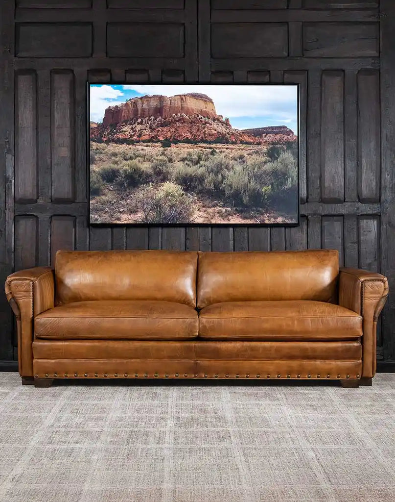 Sierra Range Leather Sofa showcasing its full-grain leather upholstery and hand-painted mountain landscape by artisan Wayne Parmenter.