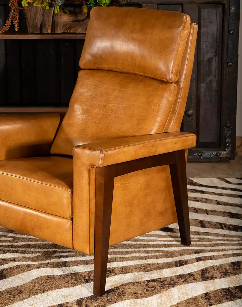 A side-angle shot of the recliner, displaying its smooth saddleback leather and elegant design.