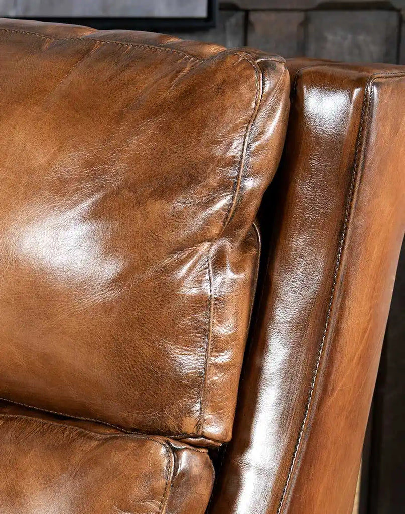 A detailed close-up of the Stanford Recliner’s hand-burnished full-grain leather, emphasizing its rich texture and natural tones.