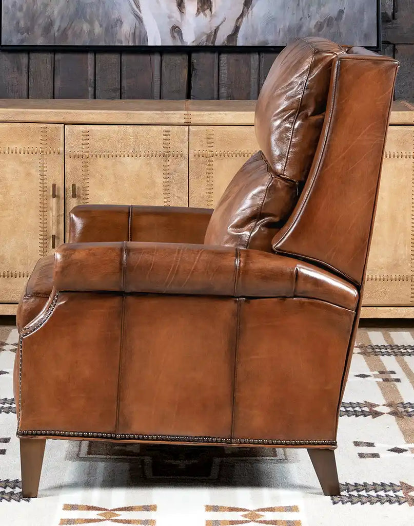 A side profile of the Stanford Brown Leather Recliner highlighting its spacious silhouette and elegant brass nail tacks.