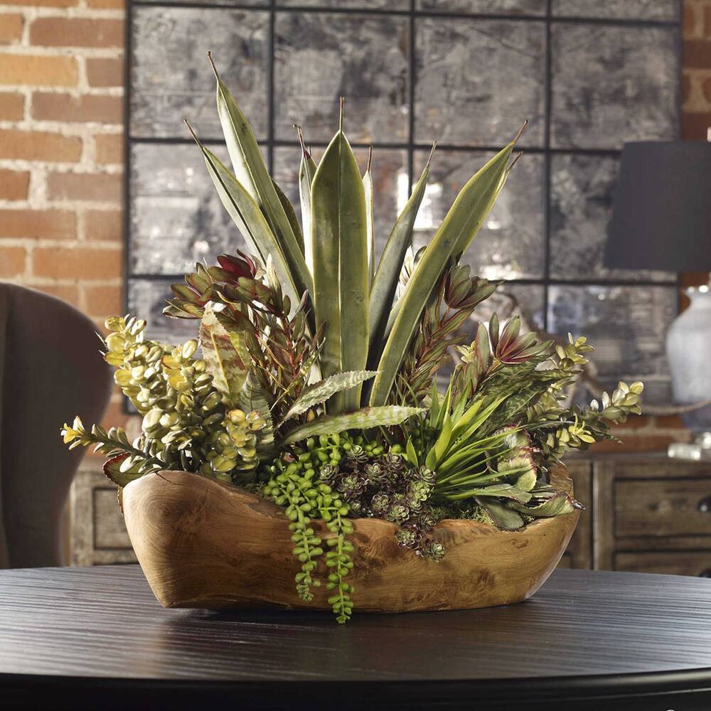 A lush arrangement of aloe, jade, bromeliad, and string of pearls succulents displayed in a handcrafted teak bowl.