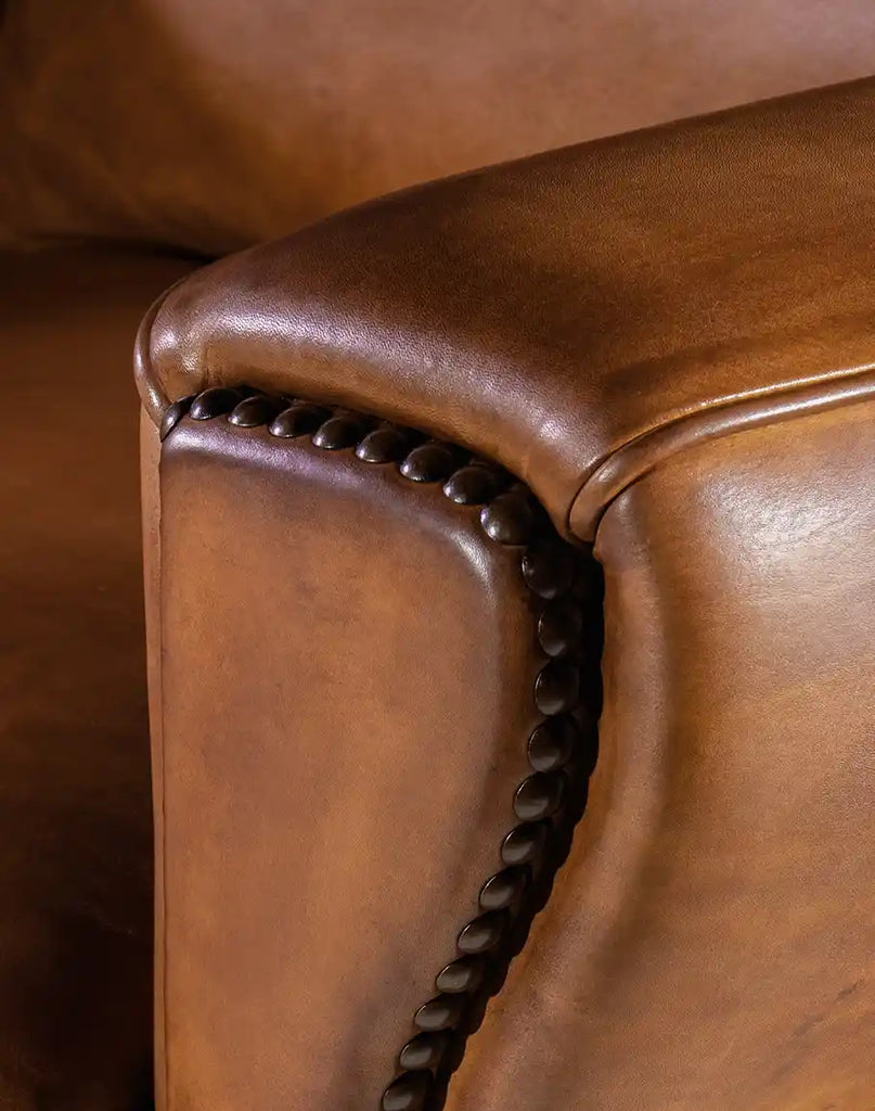 Intricate nailhead detailing along the edges of the Stockman Leather Chair, enhancing its rustic appeal.