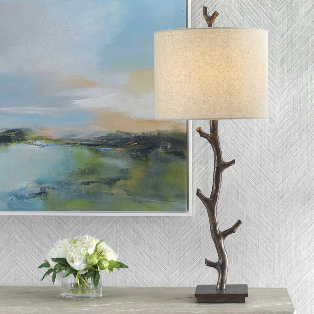 Surculus Table Lamp with a tree-branch design in dark bronze and gold undertones, paired with an oatmeal linen shade.