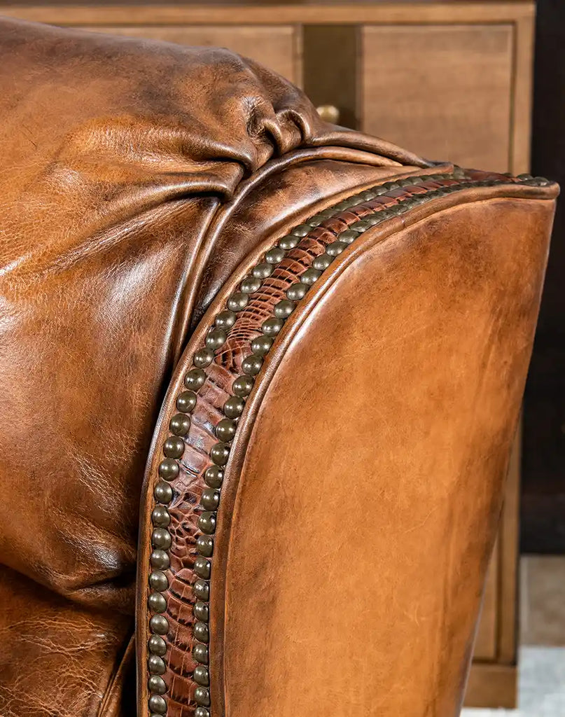 Close-up of the embossed leather accents on the arm panels and wings of the Tan Bronco Leather Recliner.