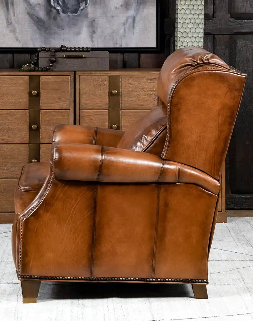 Side view of the Tan Bronco Leather Recliner highlighting its embossed leather accents and brass nail tacks.