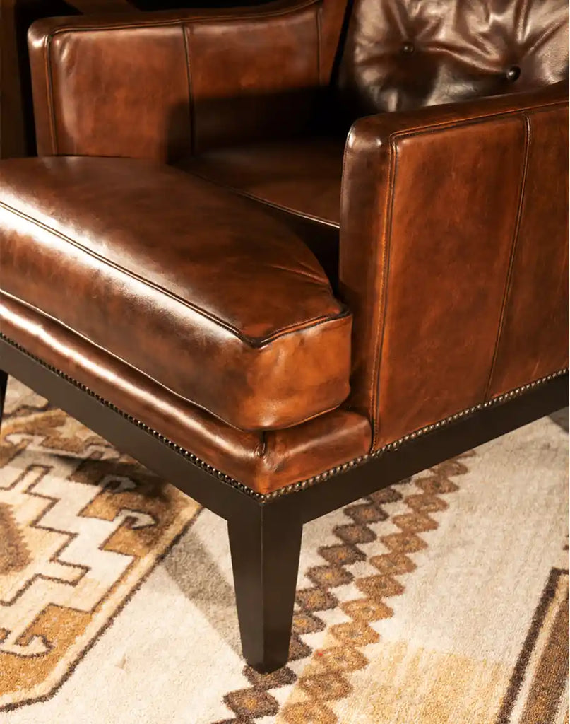 A close-up of the sturdy base and legs of the Tan Saddleback Leather Chair, crafted from durable materials to ensure long-lasting quality.