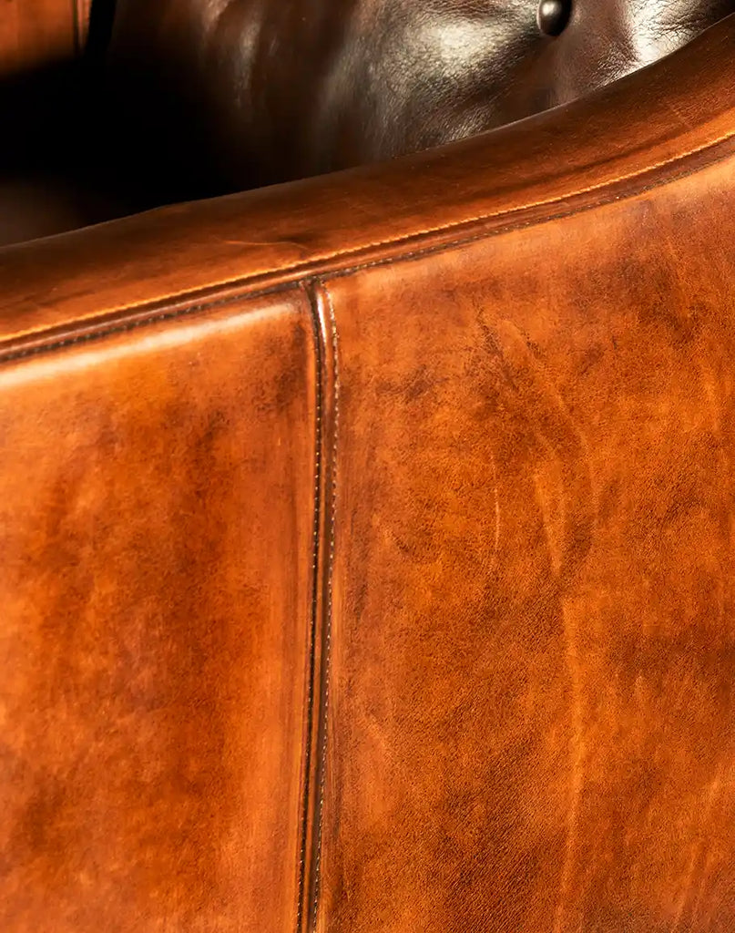 A close-up of the Tan Saddleback Leather Chair’s hand-burnished leather, emphasizing its rich tan tones and premium quality finish.