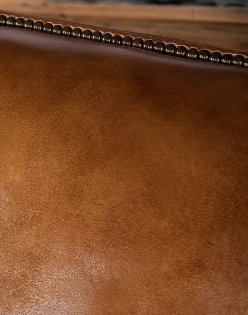 Close-up of the hand-burnished full-grain leather seat of the Pioneer Club Chair, emphasizing its rich texture.