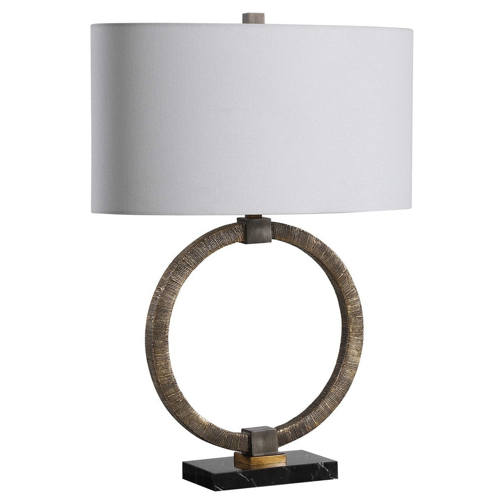 Bohemian table lamp with a richly antiqued gold base, dark bronze details, and a sleek black marble stand topped with a white linen shade.