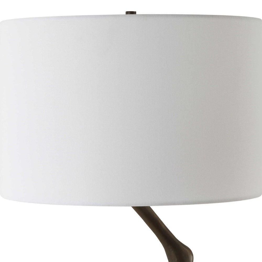 Modern bird-leg table lamp showcasing an antique bronze cast iron base and a clean white linen drum shade for contemporary decor.