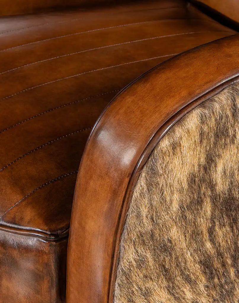 Close-up of the brindle cowhide craftsmanship on the armrest of the Vaquero Swivel Chair.