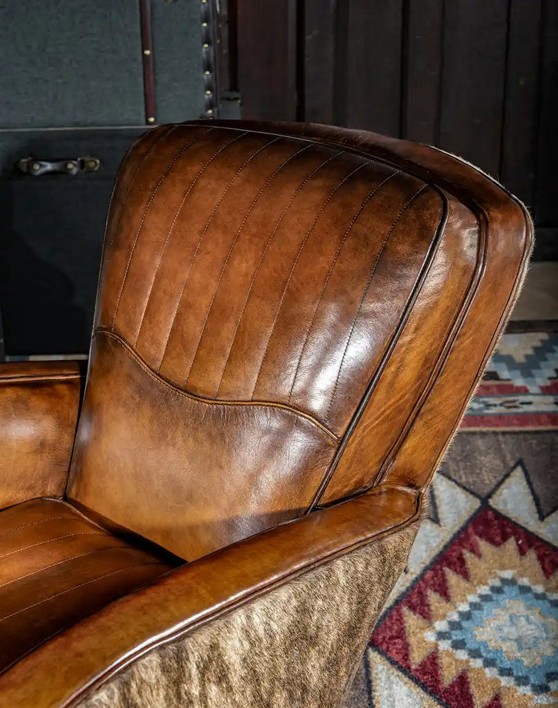 Hand-burnished leather with parallel stitching on the back headrest of the Vaquero Swivel Chair.