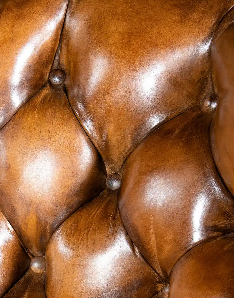 A detailed shot of the deep tufting on the chair’s back, emphasizing its luxurious texture and comfort.