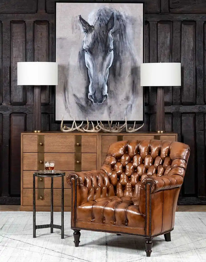 Full view of the leather lounge chair with an antique finish and tufted details.