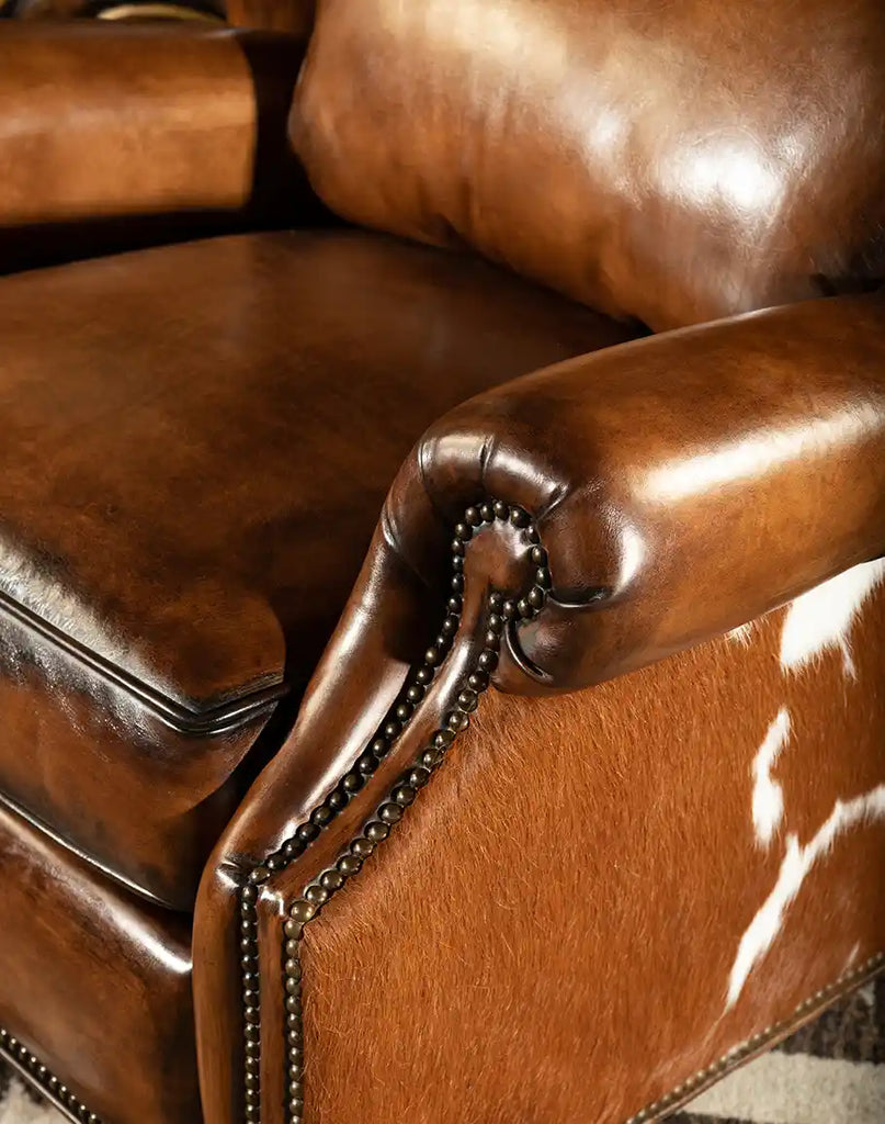 The Scottie Leather Recliner showcasing its Western-style aesthetic, complete with brass nailhead trim and cowhide details.