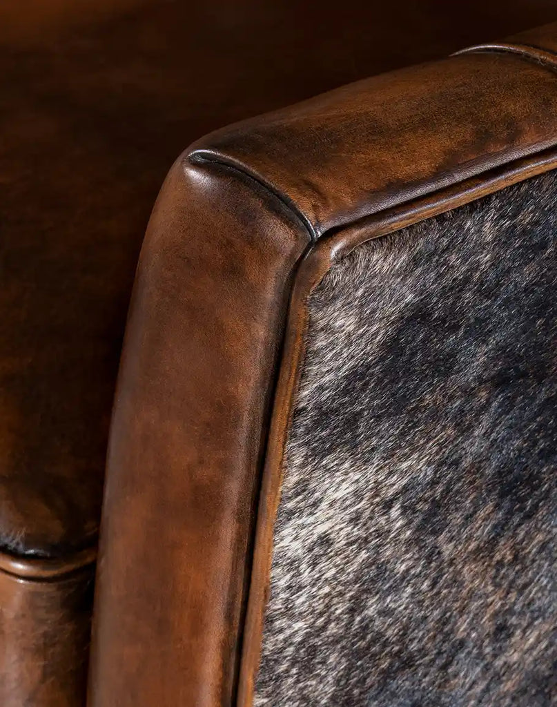 A detailed shot of the brindle cowhide wrapped around the edges and back of the Westlife Leather Chair.