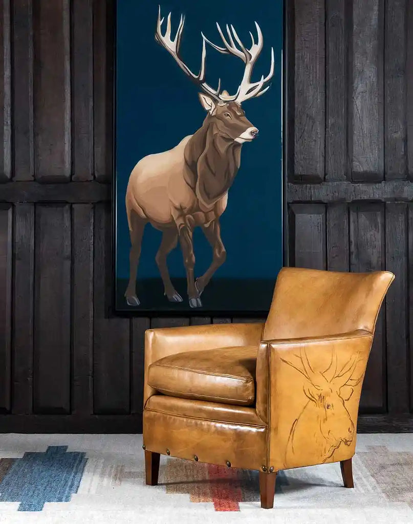 The Wild Elk Leather Chair styled in a rustic lodge, enhancing the cozy and sophisticated ambiance.