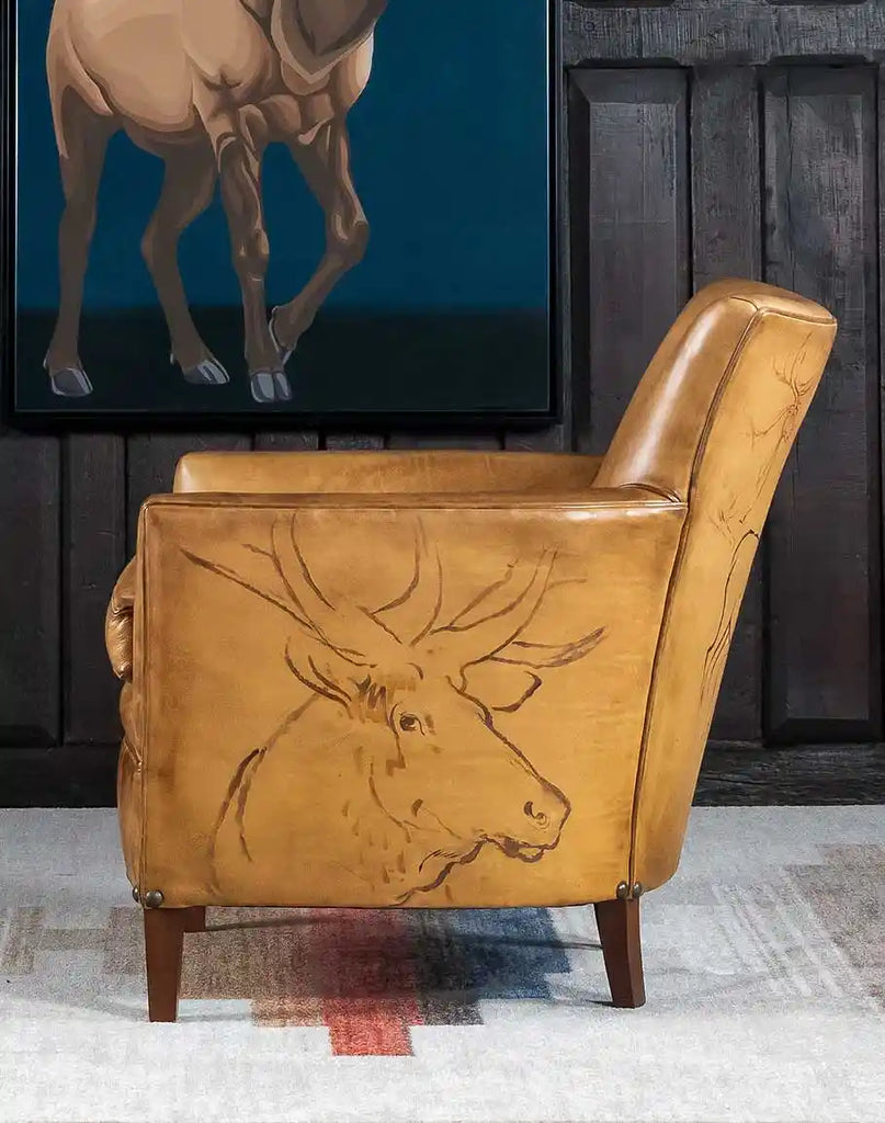 A side profile of the Wild Elk Leather Chair, highlighting its sculpted design and antique brass nailhead accents.