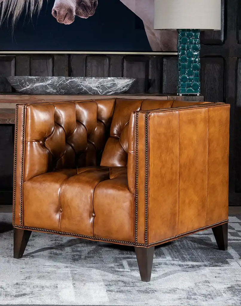 Kingston Tufted Leather Chair showcasing its deep button tufting, rich hand-burnished leather, and antique-brass nailhead trim.