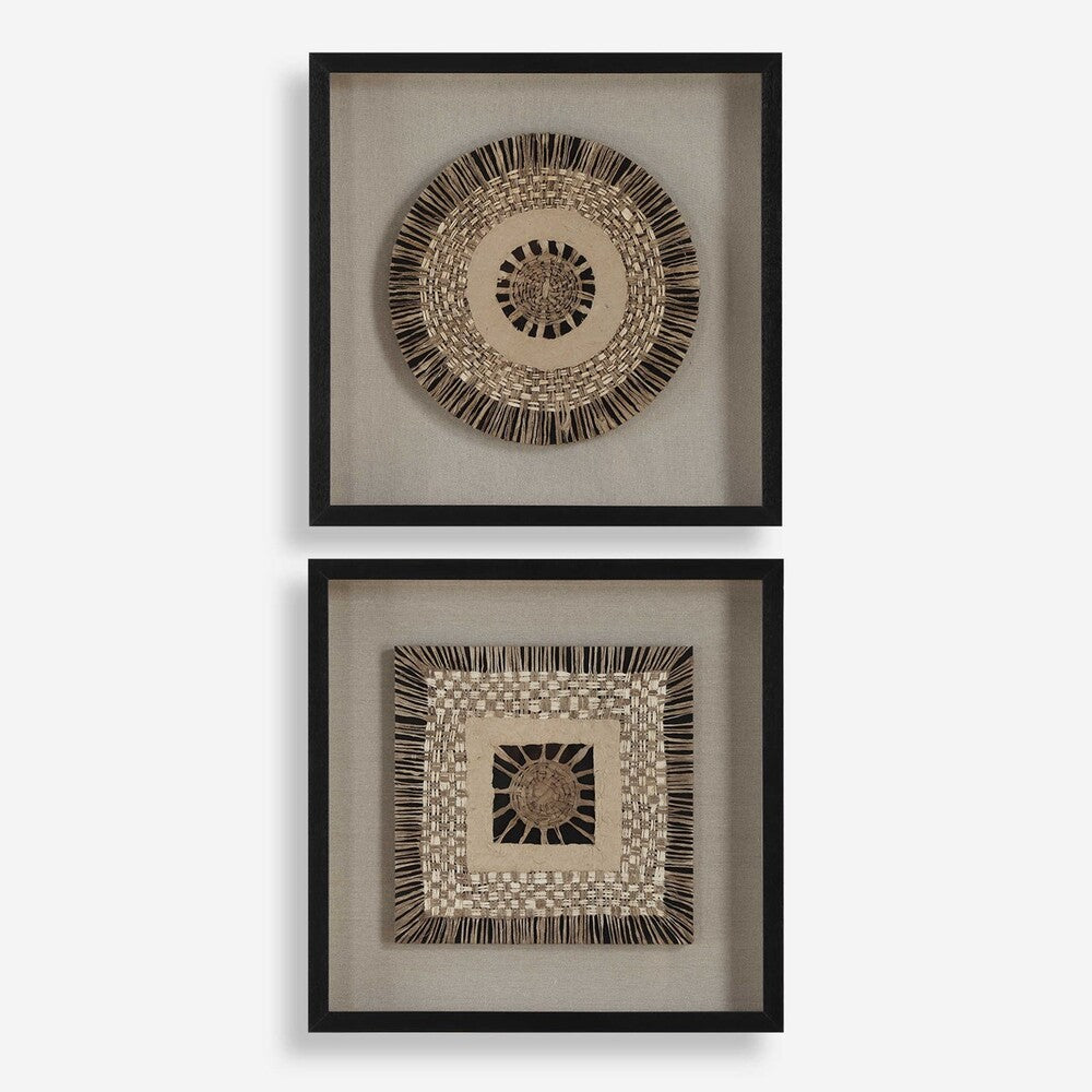 Close-up of two shadow box frames showcasing earthy woven paper designs on linen backing, displayed against a light wall with modern decor.