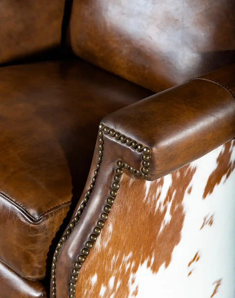 Close-up of the armrest on the Wrangler Leather Recliner, showing its smooth leather and intricate brass nail tack detailing.