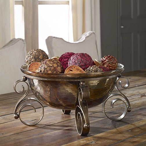 The Alia bowl placed on a rustic wooden table, styled as a decorative centerpiece to enhance the space with its unique metallic charm.