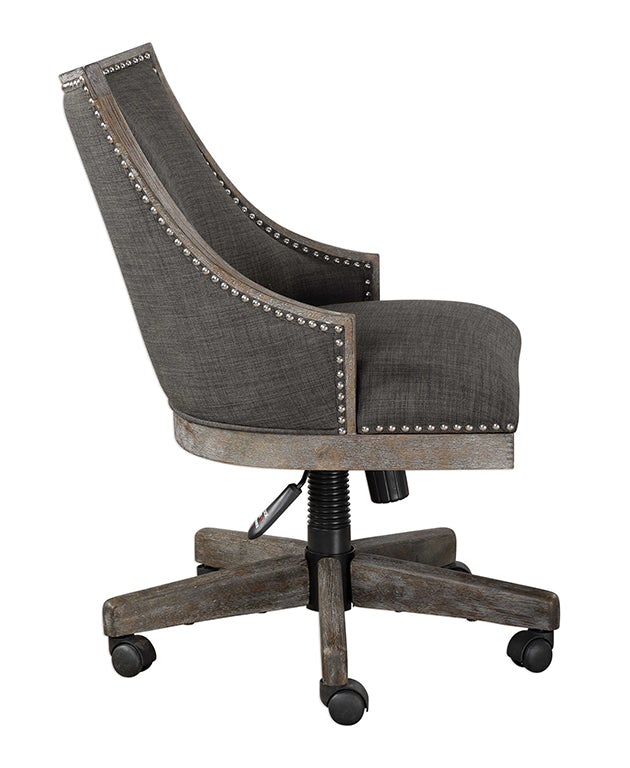 Sophisticated Adrian desk chair with a curved charcoal gray linen back, polished nailhead trim, and sturdy honey-stained wood frame with gray wash accents.